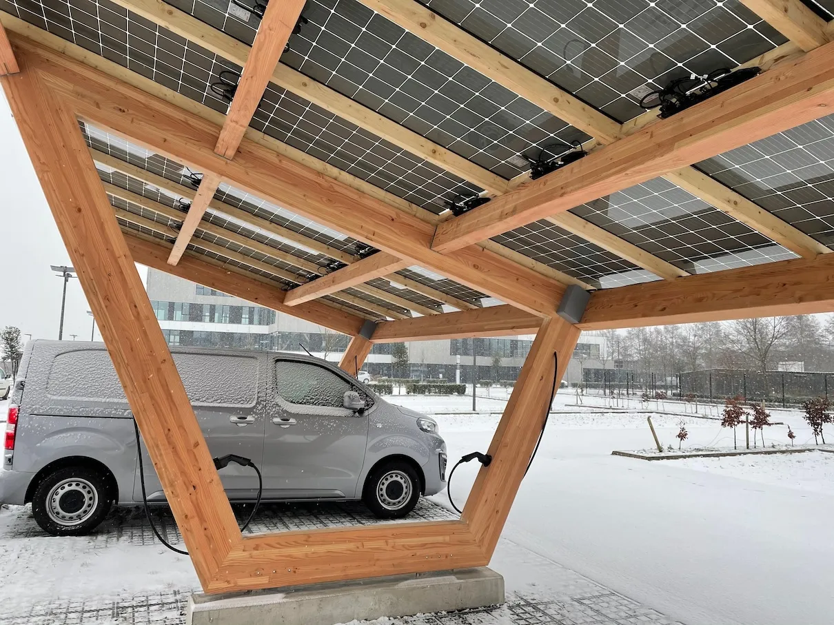 Carport solaire TOSSO en bois sous la neige avec véhicule en recharge