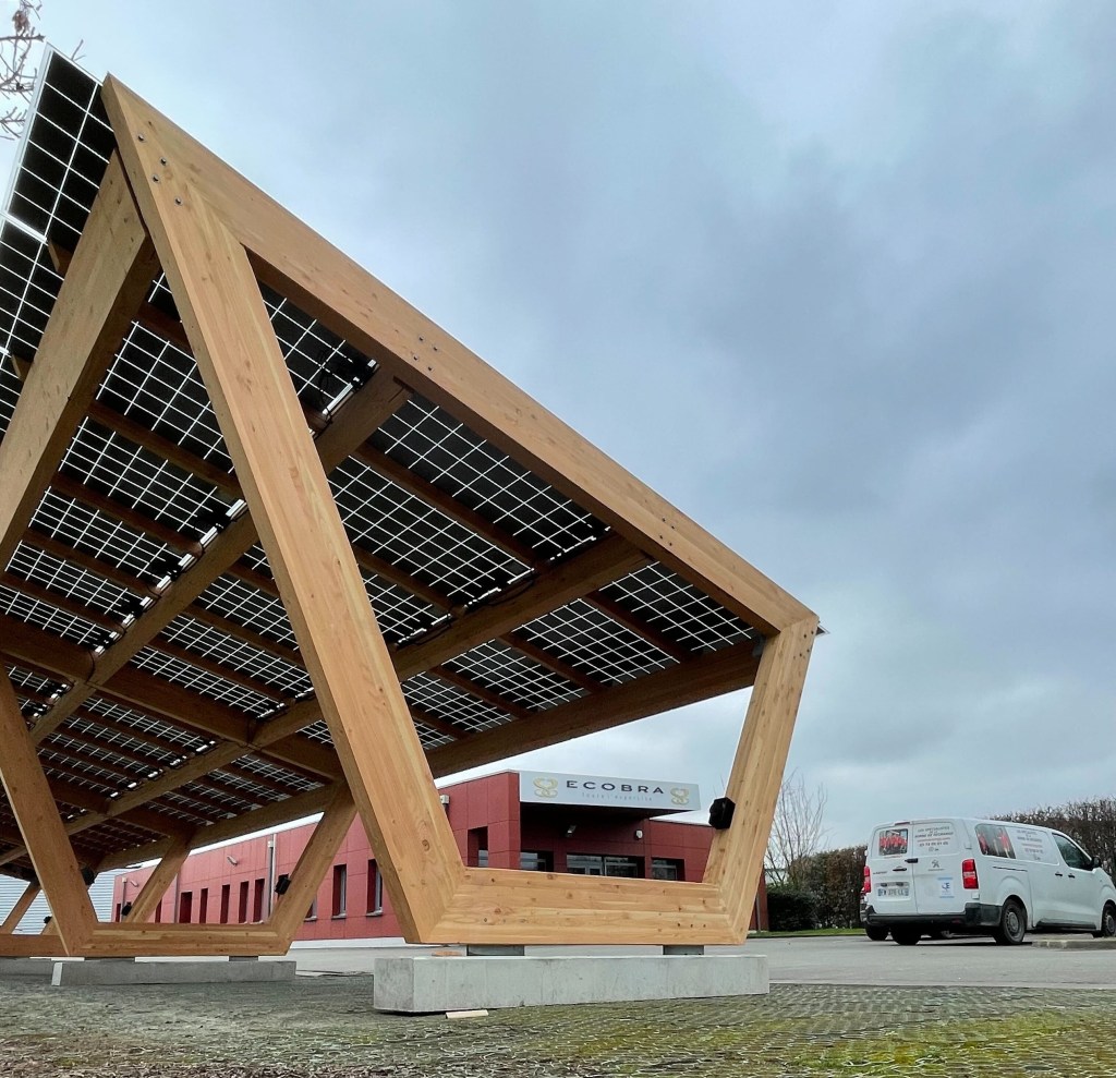 Un grand abri photovoltaïque couvrant un parking.